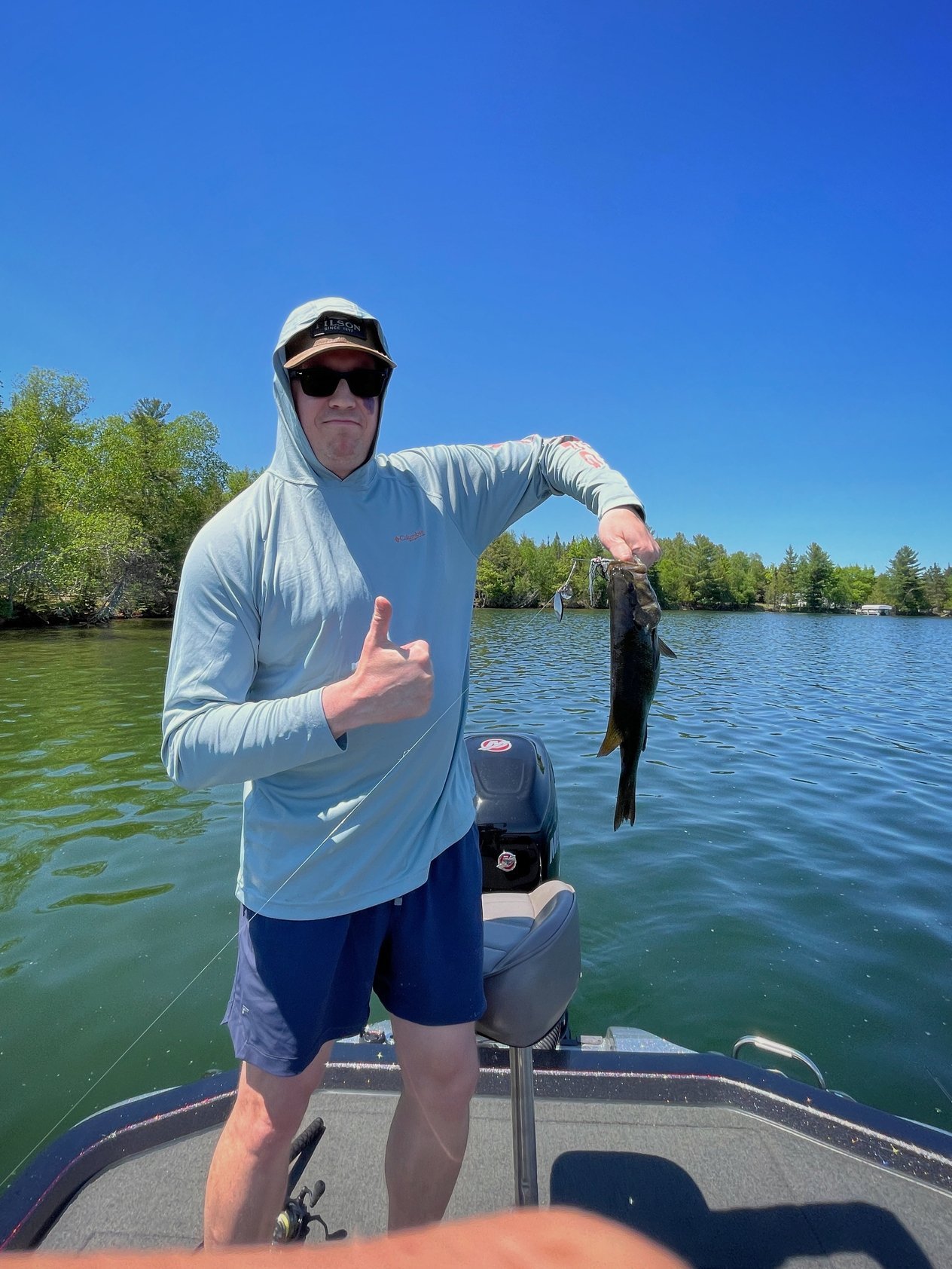 Pete McPherson on a boat holding a bass caught on a Michigan lake